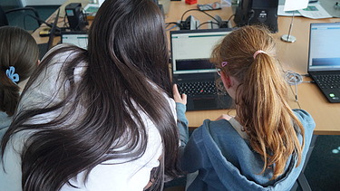 Image shows a girl receiving a software tutorial