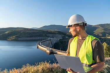 Image shows Engineer overlooking a critical infrastructure (dam)