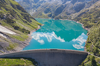 urved dam stretches across the water, holding it back