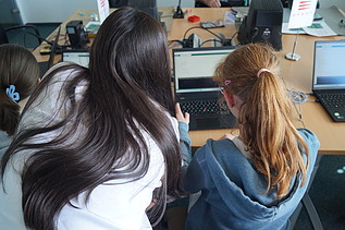 Image shows a girl receiving a software tutorial